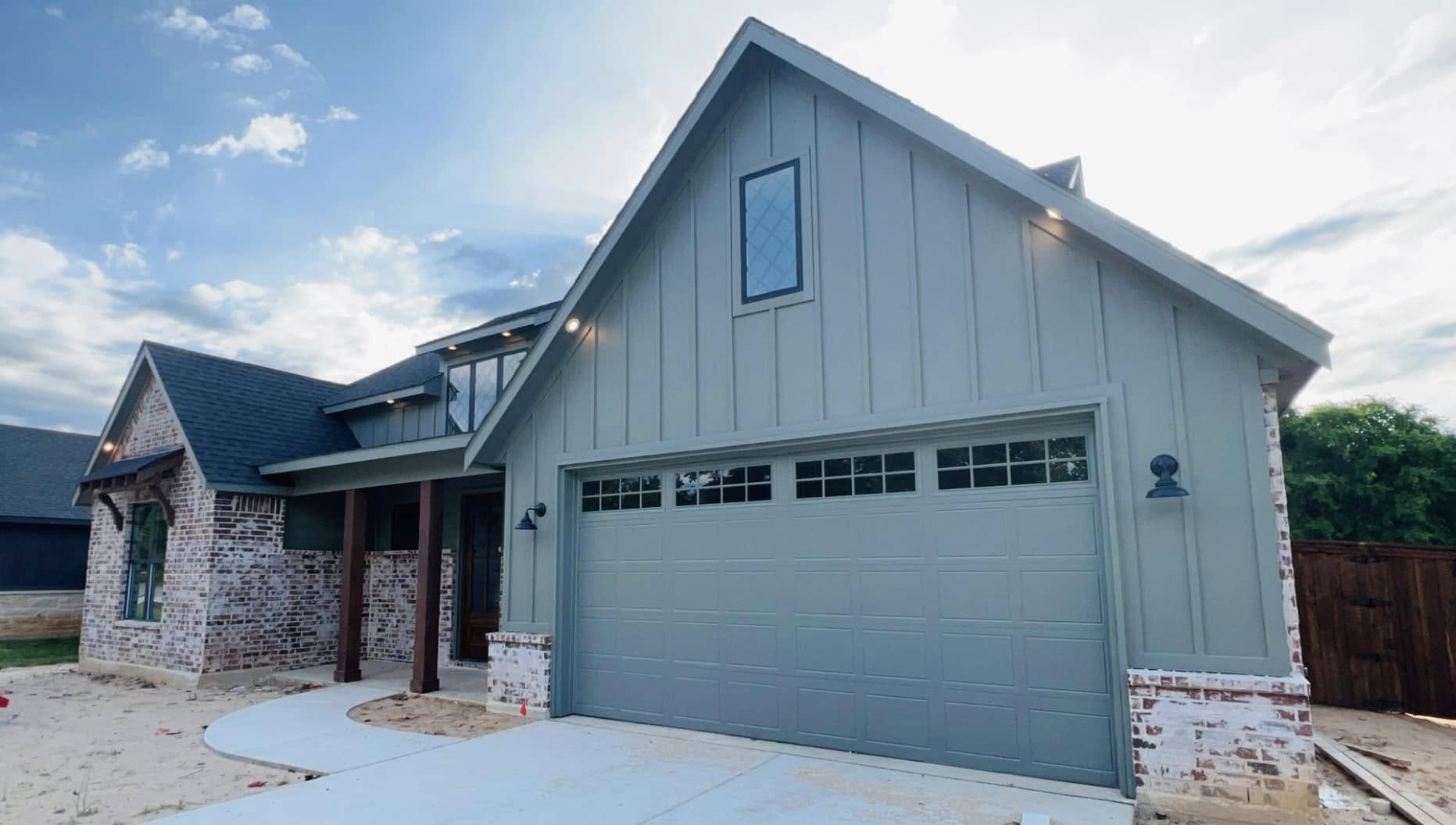 Stunning modern farmhouse exterior with custom brick and board-and-batten siding, built by premier custom home builders in Navarro County, TX.