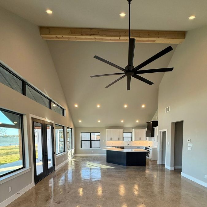 Custom home builder open concept interior featuring vaulted ceilings polished concrete floors and kitchen island in Canton TX